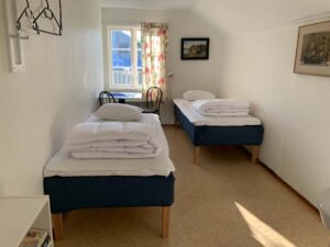 Två enkelsängar i ett mindre vandrarhemsrum.