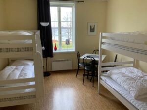 Rum med dubbla våningssängar och en mindre matplats.