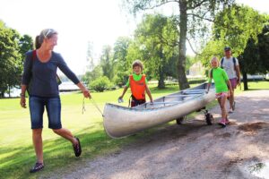 Familj som drar en kanot ner mot Helgasjön
